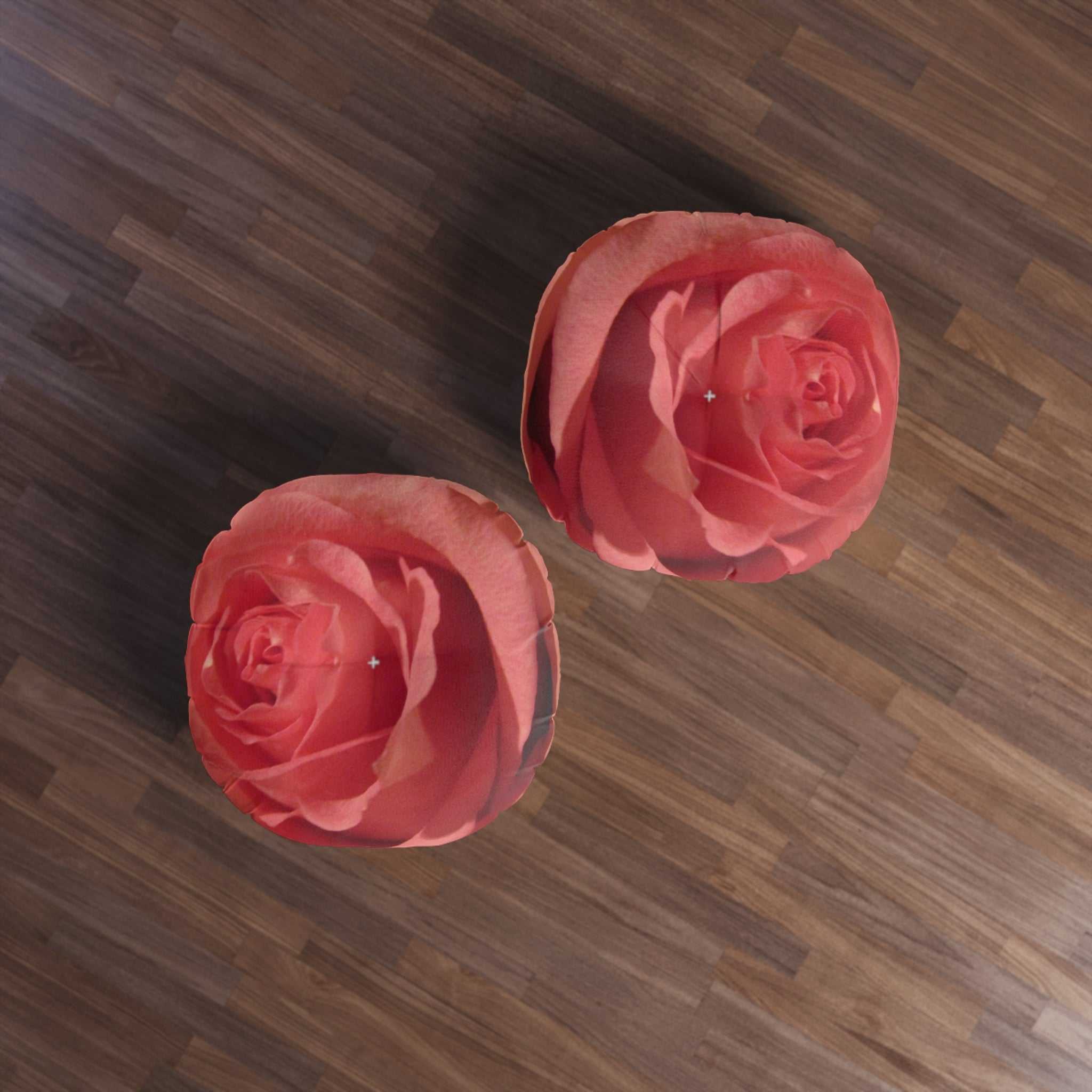 Two pink roses on a wooden floor