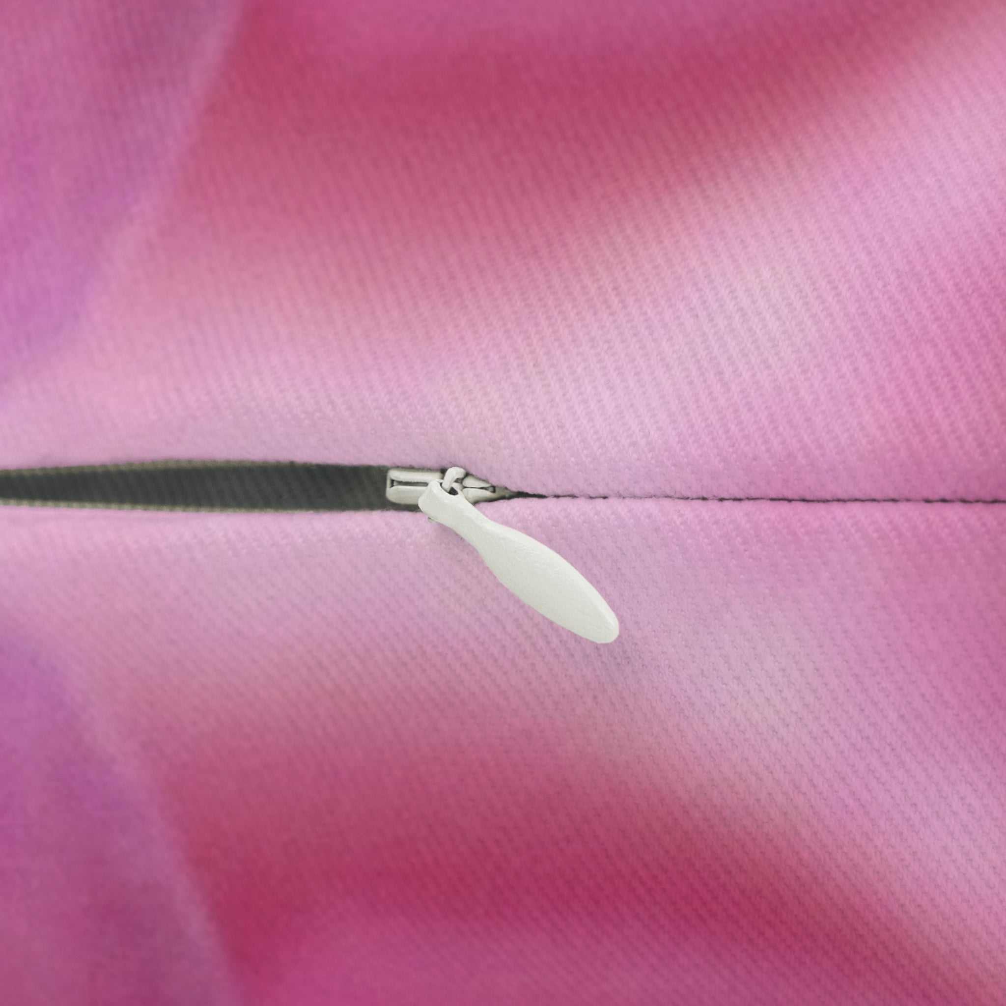 Close-up of a zipper on a pink fabric background